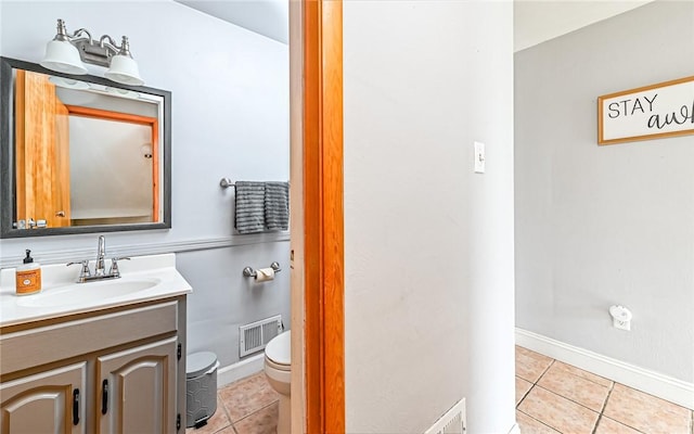 bathroom with tile patterned floors, vanity, and toilet