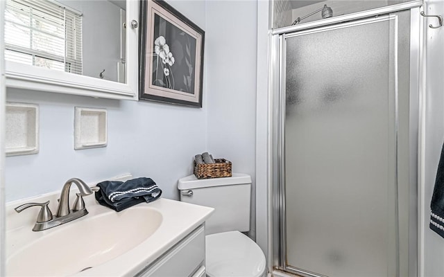 bathroom featuring vanity, toilet, and a shower with shower door