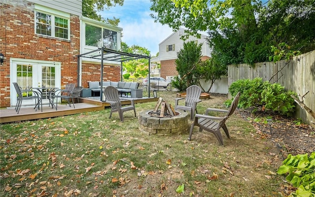 view of yard featuring a deck and an outdoor living space with a fire pit