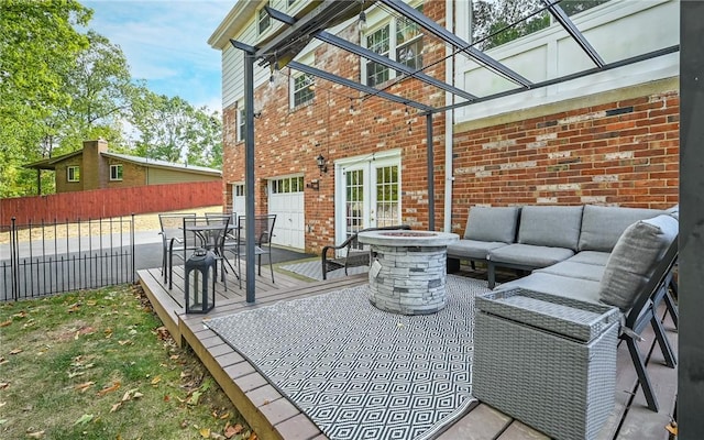 view of patio / terrace with a wooden deck and an outdoor living space with a fire pit