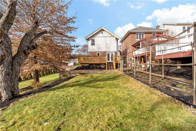 rear view of house featuring a yard and a deck