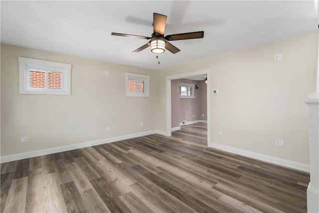 spare room featuring ceiling fan, dark hardwood / wood-style flooring, and a wealth of natural light