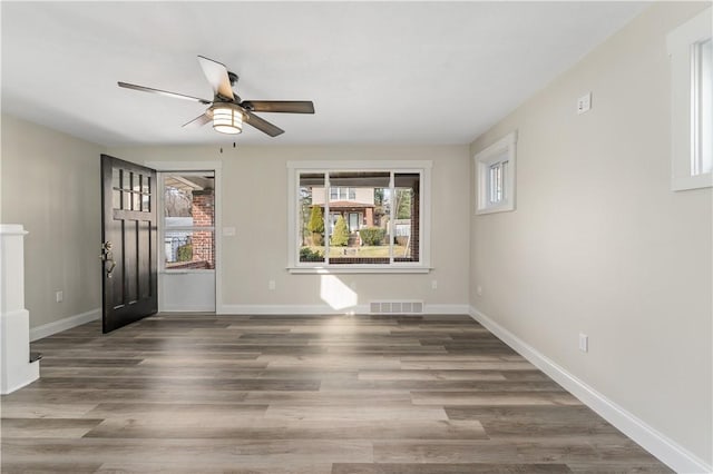 unfurnished room with ceiling fan and dark hardwood / wood-style flooring