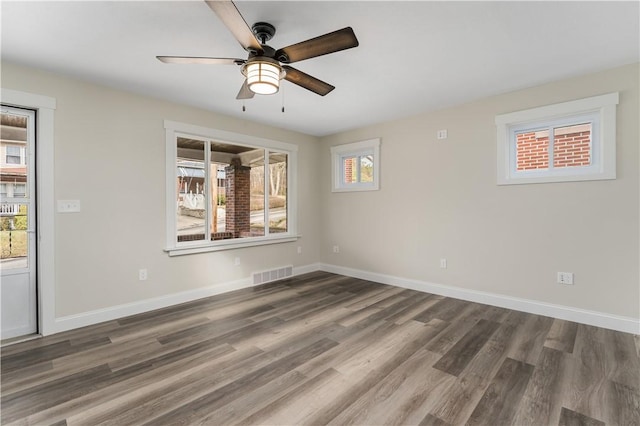 spare room featuring ceiling fan, dark wood-type flooring, and a wealth of natural light