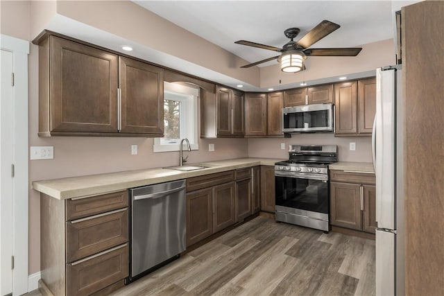 kitchen featuring ceiling fan, sink, stainless steel appliances, dark hardwood / wood-style floors, and dark brown cabinets