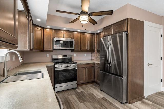 kitchen with hardwood / wood-style floors, ceiling fan, sink, and appliances with stainless steel finishes