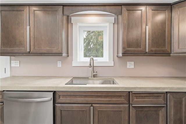 kitchen featuring stainless steel dishwasher, dark brown cabinetry, and sink