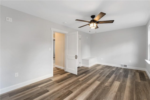 empty room with ceiling fan and dark wood-type flooring