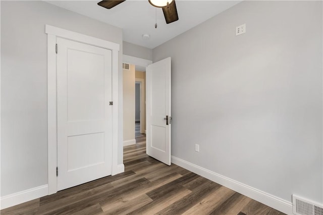 unfurnished bedroom featuring ceiling fan, a closet, and dark hardwood / wood-style floors