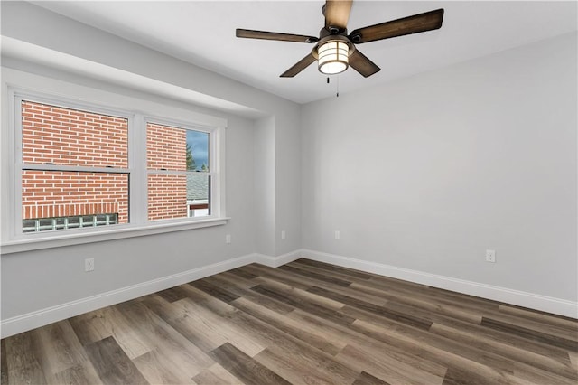 spare room with dark hardwood / wood-style floors and ceiling fan