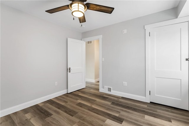 unfurnished bedroom with ceiling fan and dark hardwood / wood-style floors