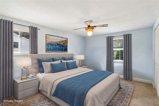 carpeted bedroom featuring ceiling fan and a closet