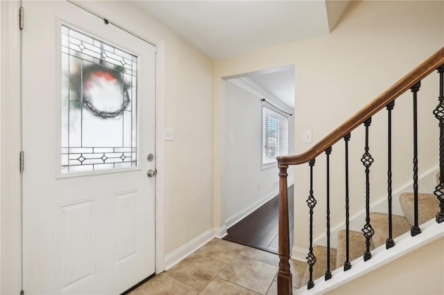 entryway featuring light tile patterned floors and crown molding