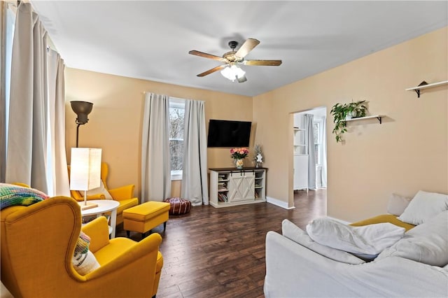 living room featuring ceiling fan and dark wood-type flooring