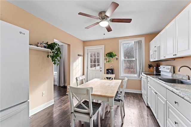 dining space with dark hardwood / wood-style flooring, ceiling fan, and sink