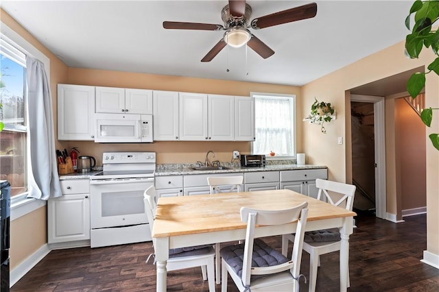 kitchen featuring white cabinets, white appliances, sink, and a wealth of natural light