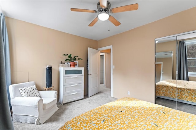 carpeted bedroom featuring ceiling fan and a closet