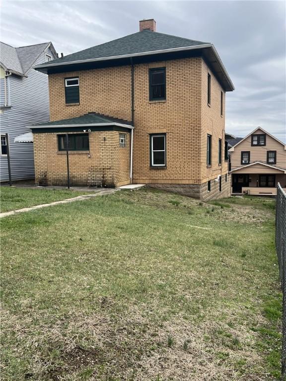 back of house featuring a lawn