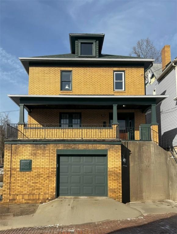 traditional style home featuring brick siding, a garage, and a balcony