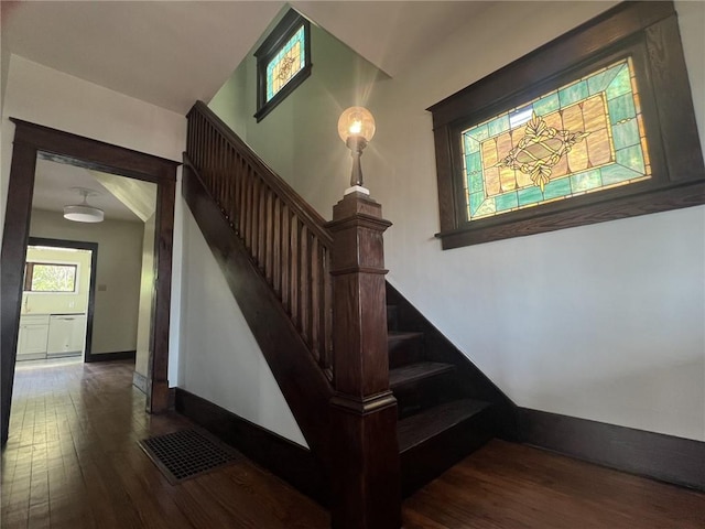 stairway featuring baseboards, visible vents, and hardwood / wood-style flooring