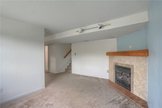 unfurnished living room with carpet and a tiled fireplace