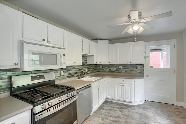 kitchen with white cabinets, appliances with stainless steel finishes, ceiling fan, and sink