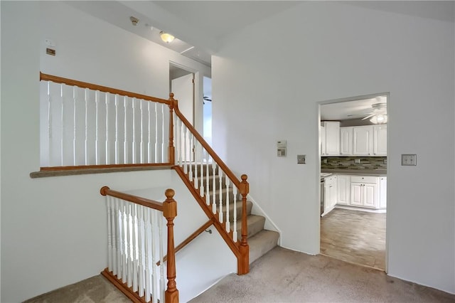 staircase with carpet and ceiling fan