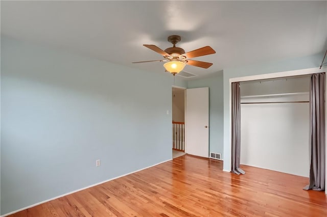 unfurnished bedroom featuring ceiling fan, a closet, and light hardwood / wood-style flooring