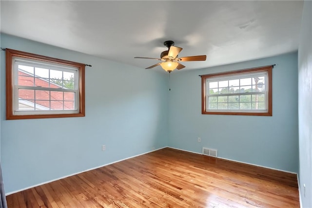 empty room with hardwood / wood-style floors and ceiling fan