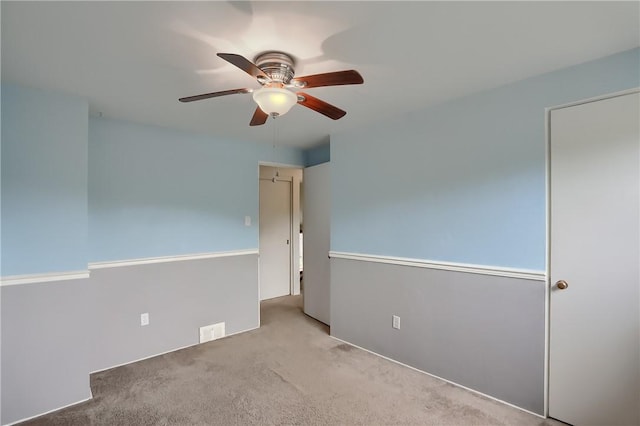 carpeted empty room featuring ceiling fan