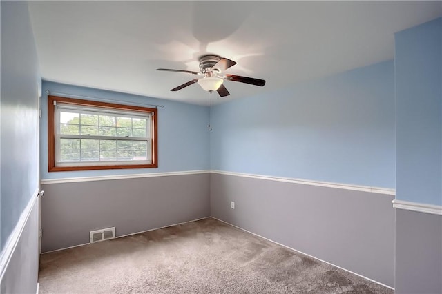 carpeted spare room featuring ceiling fan