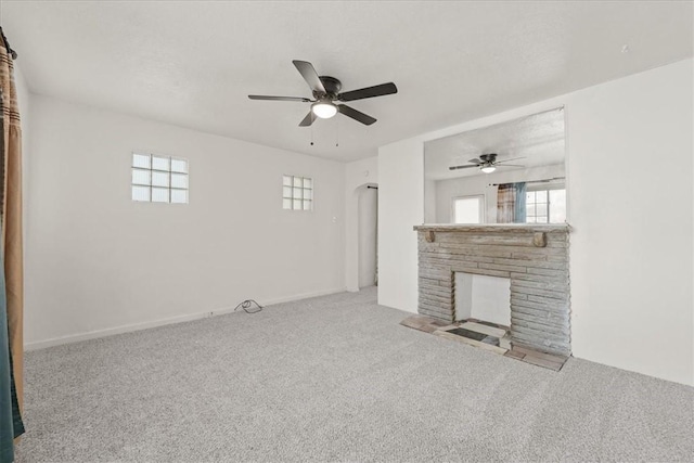 unfurnished living room with light carpet, a fireplace, and ceiling fan