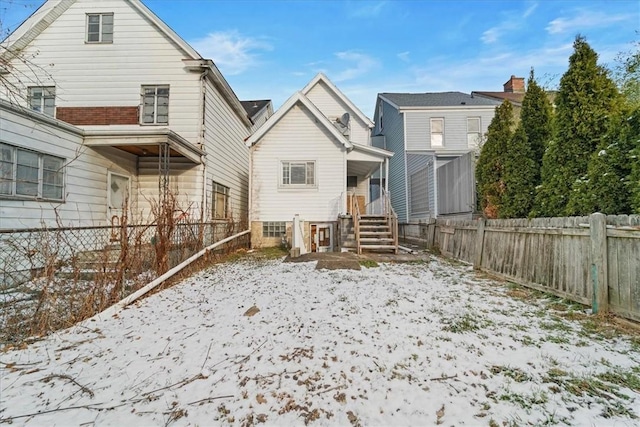 view of snow covered rear of property