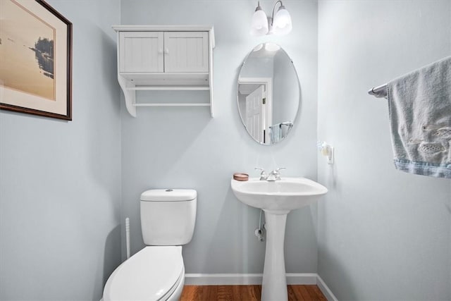 bathroom featuring a chandelier, wood-type flooring, toilet, and sink