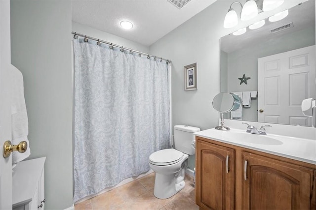 bathroom featuring toilet, a textured ceiling, vanity, and tile patterned floors