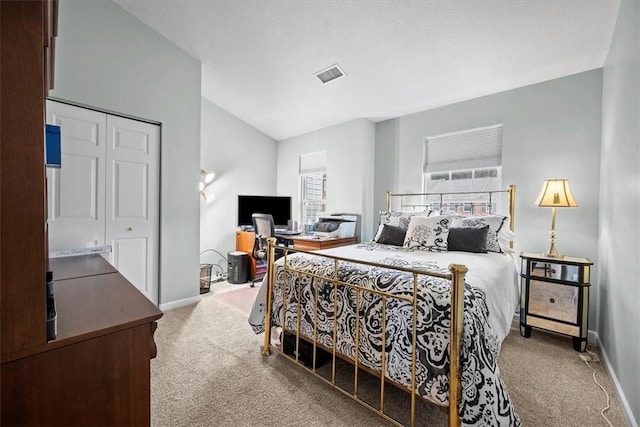 carpeted bedroom featuring lofted ceiling and a closet