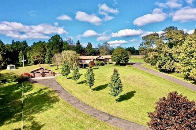 view of home's community with an outdoor structure and a yard