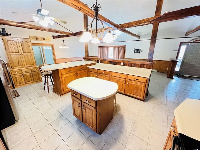 kitchen with wood walls, decorative light fixtures, a kitchen island, and a kitchen breakfast bar