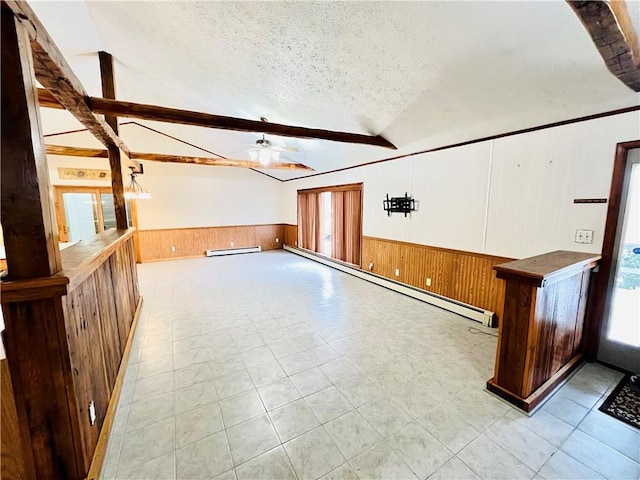 additional living space with a textured ceiling, a baseboard radiator, ceiling fan, and a healthy amount of sunlight