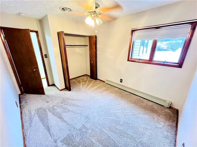 unfurnished bedroom with ceiling fan, a baseboard radiator, a textured ceiling, light carpet, and a closet