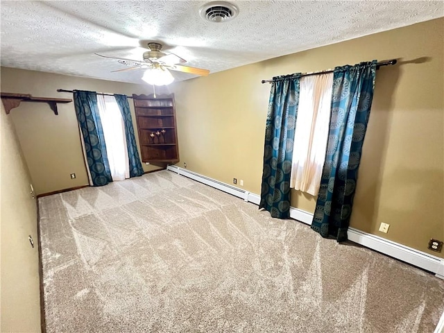 unfurnished bedroom featuring light carpet, multiple windows, baseboard heating, and ceiling fan