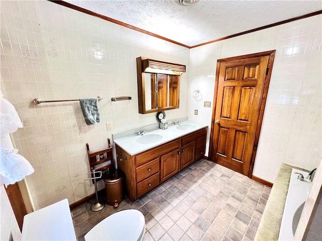 bathroom with a textured ceiling, vanity, and tile walls