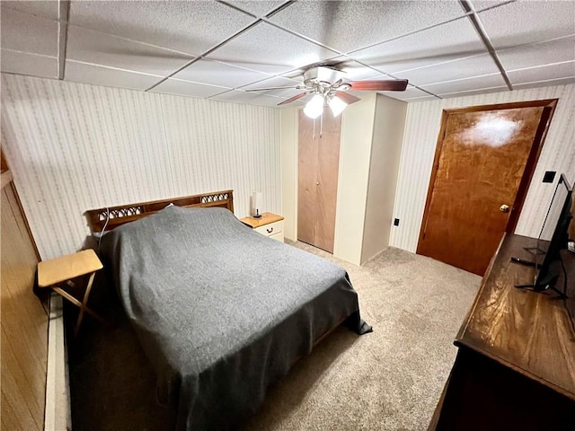 bedroom with a drop ceiling, ceiling fan, and carpet floors