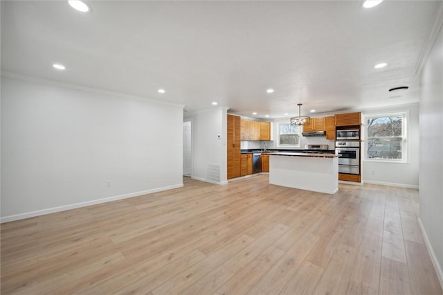 kitchen with a center island, stainless steel appliances, hanging light fixtures, crown molding, and light hardwood / wood-style floors