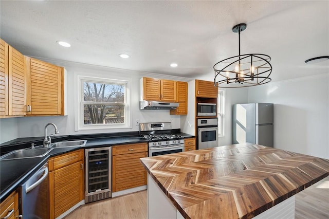 kitchen featuring wine cooler, a chandelier, decorative light fixtures, a kitchen island, and appliances with stainless steel finishes