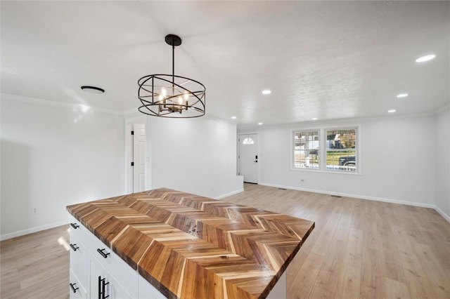 dining space with a chandelier, light hardwood / wood-style flooring, and ornamental molding