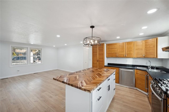 kitchen featuring white cabinetry, sink, stainless steel appliances, a chandelier, and a kitchen island