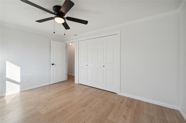 unfurnished bedroom with ceiling fan, light wood-type flooring, ornamental molding, and a closet