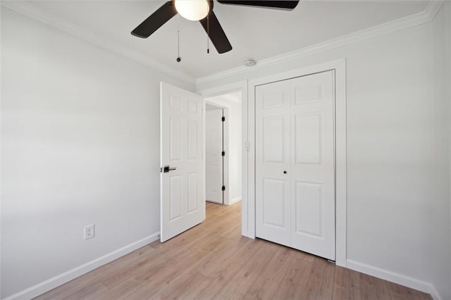 unfurnished bedroom with ceiling fan, light wood-type flooring, ornamental molding, and a closet