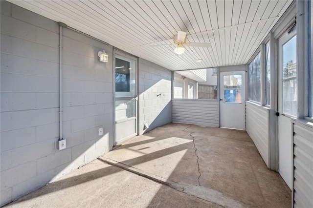 unfurnished sunroom featuring ceiling fan